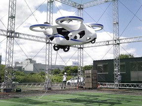 A prototype of NEC Corp.'s flying car floats in the air during a demonstration at a testing site of the company's plant in Abiko, Chiba Prefecture, Japan, on Monday, Aug. 5, 2019. The vehicle is essentially a large drone with four propellers that’s capable of carrying people. The Japanese electronics maker demonstrated the machine, flying without a passenger, at a Tokyo suburb on Monday.