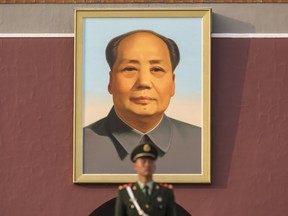 A member of the Chinese People's Liberation Army stands guard in front of a portrait of former Chinese leader Mao Zedong at Tiananmen Square in Beijing, China on Monday, Oct 16, 2017.