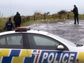 Police collect and photograph evidence in the carpark of the Te Toto Gorge lookout on Whaanga Rd, south of Raglan, New Zealand, Friday, Aug. 16, 2019. Police in New Zealand say a grieving Canadian woman is focusing on the memories she shared with her Australian fiance before he was murdered Friday in a seemingly random attack.