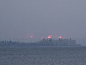 Wildfires burn across Gregoire Lake near Fort McMurray, Alta., on Thursday, May 5, 2016. Very wet conditions this year and fire-damaged soils from the 2016 Fort McMurray wildfire are causing healthy-looking trees at Gregoire Lake to fall down, even in moderate winds.
