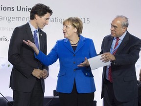 Canadian Prime Minister Justin Trudeau speaks with German Chancellor Angela Merkel and OECD Secretary General Angel Gurria at the start of a session on carbon pricing at the United Nations climate change summit, Monday November 30, 2015 in Le Bourget, France. An international review of Canada's economic immigration system says the country is doing well when it comes to how it selects and welcomes foreign workers.THE CANADIAN PRESS/Adrian Wyld