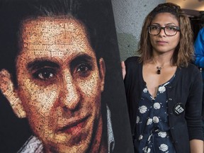 Ensaf Haidar, wife of Raif Badawi, stands next to a poster of a book of articles written by the imprisoned Saudi blogger, Tuesday, June 16, 2015 in Montreal.