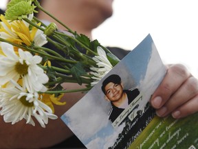 A woman holds a copy of the program at a vigil in honor of Javier Rodriguez, who was killed while shopping at Walmart.