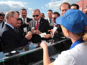 A handout picture taken and released on August 27, 2019 by the Turkish Presidential Press service shows Russian President Vladimir Putin (L) and his Turkish counterpart Recep Tayyip Erdogan (R) stopping for an ice cream during the MAKS 2019 International Aviation and Space Salon opening ceremony in Zhukovsky outside Moscow.