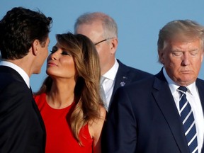 U.S. First Lady Melania Trump gives Canadian Prime Minister Justin Trudeau a cordial kiss on the cheek as the world leaders stand for a photo during the G7 summit.