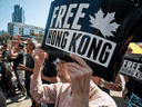 A woman listens to speakers at a rally in support of Hong Kong anti-extradition bill protesters, in Vancouver on Aug. 3, 2019.