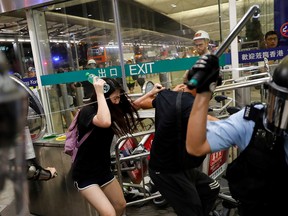 Riot police use pepper spray to disperse protesters during a mass demonstration at the Hong Kong international airport on Aug. 13, 2019.