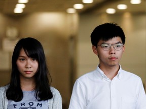 Pro-democracy activists Joshua Wong and Agnes Chow leave the Eastern Court after being released on bail in Hong Kong.