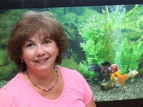 Fish hobbyist, Yvonne Maschke, in front of her aquarium of fishes that she is rehoming over Kijiji.