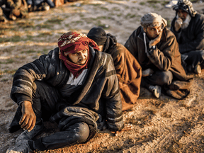 Suspected Islamic State fighters wait to be searched by Kurdish-led Syrian Democratic Forces in February 2019.