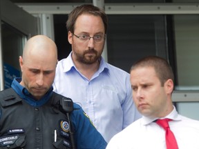 Jonathan Bettez is escorted out of the palais de justice of Trois Rivieres on Tuesday August 30, 2016.