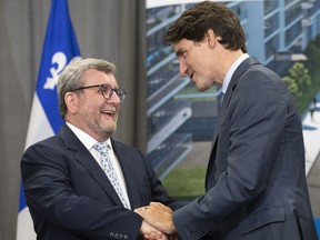 Prime Minister Justin Trudeau, right, shakes hand with Quebec City mayor Regis Labeaume after they announced a major investment for a tramway, Monday, August 19, 2019 in Quebec City.