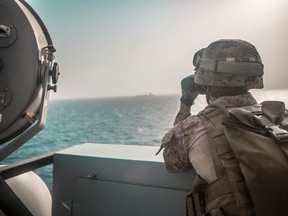 U.S. Marine Corps Cpl. Michael Weeks, ranges nearby boats from USS John P. Murtha during a Strait of Hormuz transit, Arabian Sea off Oman, in this picture released by U.S. Navy on July 18, 2019.
