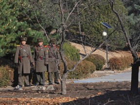 This file photo taken on November 27, 2017 shows North Korean soldiers staring at the South side at the truce village of Panmunjom in the Demilitarized zone (DMZ) dividing the two Koreas.A North Korean soldier defected by making a perilous midnight journey across the heavily fortified demilitarized zone into South Korea, defense officials in Seoul said Thursday.
