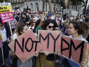 Demonstrators carry placards as they protest against Britain's newly appointed prime minister Boris Johnson outside Downing Street in London on July 24, 2019.