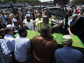 Mourners accompany one of the four caskets of the Zaman family into a hearse after a funeral service at a mosque in Toronto on Friday, Aug. 2, 2019.