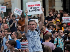 People take part at a rally calling for opposition candidates to be registered for elections to Moscow City Duma, the capital's regional parliament, in Moscow, Russia July 27, 2019. The placard reads: "I have a right to my candidate".