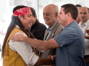 Mohawk Grand Chief Serge Simon, left, shakes hands with Oka Mayor Pascal Quevillon in 2015. The two shook hands again on Aug, 30, 2019 to end tension over a land dispute.