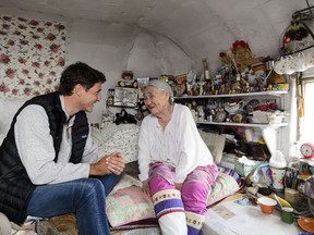 Prime Minister Justin Trudeau talks with Inuit elder Qaapik Attagutsiak, 99, in her tiny home during a visit to Arctic Bay, Nvt., on Thursday, Aug. 1, 2019.  Sitting on a bed next to the oldest Inuit woman in northern Nunavut, Prime Minister Justin Trudeau heard and witnessed first-hand what life is like for the people of the Far North.