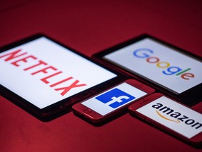 The logos for Facebook Inc., Amazon.com Inc., Netflix Inc. and Google, a unit of Alphabet Inc., sit on smartphone and tablet devices.