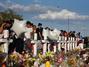 People gather to pay their respects at a growing memorial three days after a mass shooting at a Walmart store in El Paso, Texas, U.S. August 6, 2019.