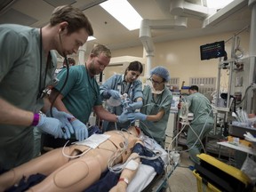 Staff at the downtown Toronto facility hear the declaration of a "code orange" and whir into action -- they know it's a simulation designed to test the hospital's response to catastrophe but their reaction to the situation is real. Dr. Christopher Tsoutsoulas (left to right), Dr. Craig Brick, Diana Kanlic and Dr. Clare Toguri, tend to a medical mannequin in the trauma bay during a mass casualty simulation at St. Michael's Hospital in Toronto on Tuesday, August 13, 2019.