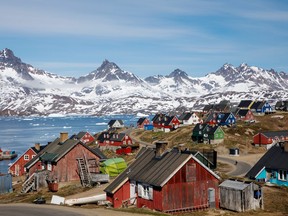 Snow covered mountains rise above the harbour and town of Tasiilaq, Greenland, June 15, 2018.