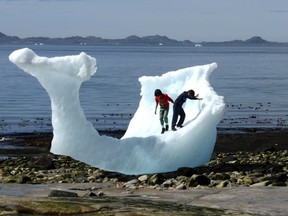 Children play amid icebergs on the beach in Nuuk, Greenland, June 5, 2016.