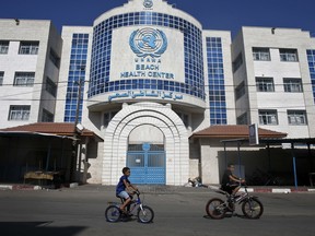 Children ride their bicycles in front of a health centre run by the United Nations Relief and Works Agency (UNRWA) in Gaza City in a file photo from October 2018. An internal ethics report has alleged mismanagement and abuses of authority at the highest levels of the UN agency for Palestinian refugees even as the organization faced an unprecedented crisis after U.S. funding cuts.