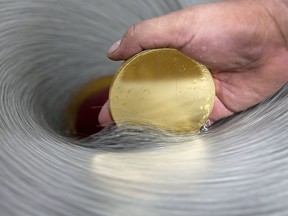 A one kilo blank gold coin is polished at the Mexican Mint, also known as Casa de Moneda, in San Luis Potosi, Mexico, on Wednesday, Oct. 5, 2011.