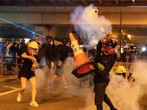 A protesters throw tear gas at police in Kwai Fong district on August 11, 2019 in Hong Kong, China. Pro-democracy protesters have continued rallies on the streets of Hong Kong against a controversial extradition bill since 9 June as the city plunged into crisis after waves of demonstrations and several violent clashes. Hong Kong's Chief Executive Carrie Lam apologized for introducing the bill and declared it "dead", however protesters have continued to draw large crowds with demands for Lam's resignation and complete withdrawal of the bill.