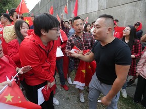 Pro-China counter-protesters, wearing red, shout down a man in a black shirt during an anti-extradition rally for Hong Kong in Vancouver on Saturday August 17, 2019. Violent demonstrations in the former British territory of Hong Kong are now in their 11th weekend.