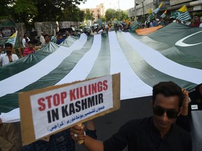 Demonstrators hold a giant flag of Pakistan-administered Kashmir during an anti-Indian protest in Karachi on August 18, 2019.