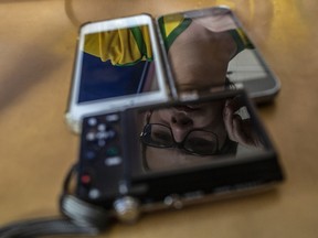 Reflected in devices, Matheus Dominguez, who said YouTube was crucial to shifting his political views to the far right, recording a YouTube video in Niterói, Brazil, April 29, 2019.