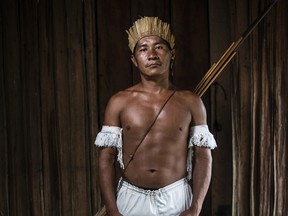 A warrior of the Munduruku tribe stands in traditional dress in his village on the banks of the Tapajos river in April 2019 in Sawre Muybu, Para, Brazil.