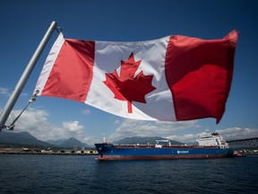 A Canadian flag flies from a Harbour Authority patrol boat as the Nord Steady oil and chemical tanker is guided by tugboats out of the Port of Vancouver in Vancouver, British Columbia, July 11, 2017.