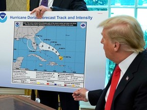 U.S. President Donald Trump references a map held by acting Homeland Security Secretary Kevin McAleenan while talking to reporters following a briefing from officials about Hurricane Dorian in the Oval Office at the White House September 04, 2019 in Washington, DC.