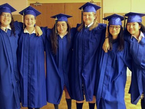 Six students in blue graduation robes attend the Giles School's graduation in 2019.