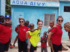 HNMCS students in red shirts interact with children during their trip to the Dominican Republic.