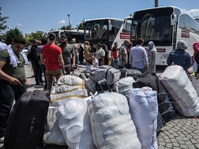 In this file photo taken on August 06, 2019, Syrian refugee families wait with other volunteers to board buses returning to neighbouring Syria in the Esenyurt district of Istanbul.