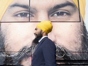 NDP leader Jagmeet Singh walks past the campaign bus during a campaign stop in Longueuil, Que. Monday September 16, 2019.