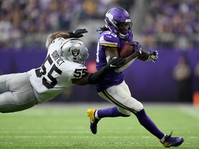 Dalvin Cook #33 of the Minnesota Vikings avoids a tackle by Vontaze Burfict #55 of the Oakland Raiders during the second quarter of the game at U.S. Bank Stadium on September 22, 2019 in Minneapolis, Minnesota.