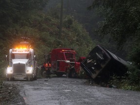 Search and rescue crews and RCMP help a tow-truck crew to remove a bus from the ditch of a logging road near Bamfield, B.C., on Saturday, September 14, 2019.