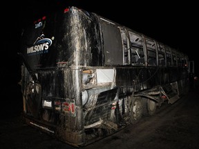 A passenger bus involved in an accident along a logging road Friday night is carried from the crash scene by a tow-truck near Bamfield, B.C. on Saturday, September 14, 2019. Two 18-year-old students, a woman from Manitoba and an American man, have been identified as the victims of a fatal bus crash on Vancouver Island.