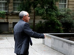 Shaun Rootenberg, alias Shaun Rothberg, tries to avoid a photographer outside Superior Court in Toronto on Thursday, Sept. 12, 2019. Rootenberg was found guilty in July of defrauding a woman he had met on the internet of $595,000 by diverting funds she gave him to invest for her. He is seeking a mistrial before sentencing.