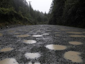 Dodging potholes is common along the Bamfield Main that leads to Bamfield, B.C. on Saturday, Sept. 14, 2019. British Columbia Premier John Horgan is expected to meet with Indigenous leaders on Vancouver Island next week to discuss the state of a treacherous logging road where two students died in a bus crash.