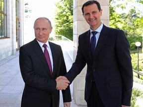 In this May 17, 2018, file photo, Russian President Vladimir Putin, left, shakes hands with Syrian President Bashar Assad during their meeting in the Black Sea resort of Sochi, Russia. Outrage over a sympathizer of Syrian President Bashar Assad having been approved as that country's honorary consul in Montreal emerged on the federal campaign trail Tuesday even as the government scrambled for answers about how it happened.