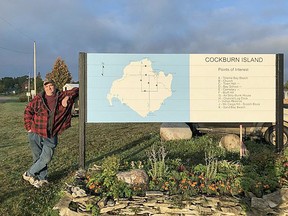Darren Rogers leans against the signpost for Cockburn Island. At 52-years-old, he has already lived on the island for 14 years and plans to stay there for the rest of his life.