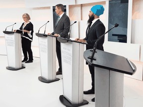 Green Party Leader Elizabeth May, Conservative Leader Andrew Scheer and NDP Leader Jagmeet Singh, along with an empty lectern where Liberal Leader Justin Trudeau would have been had he not declined to attend, at the first leaders' debate on Sept. 12, 2019, in Toronto.