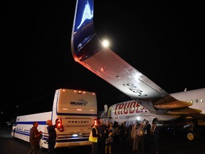 Members of the media inspect the wing from Liberal Leader Justin Trudeau's campaign plane after being struck by the media bus following landing in Victoria, B.C., on Wednesday, Sept.11, 2019.